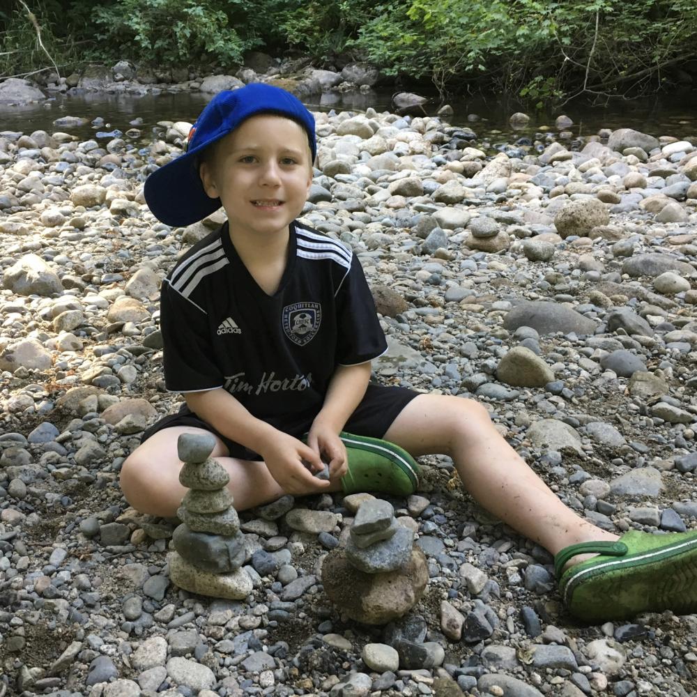 child sitting with rocks